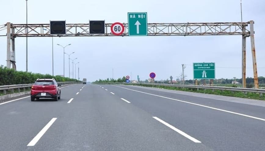Xe ô tô đỏ đang theo biển chỉ dẫn đi thẳng