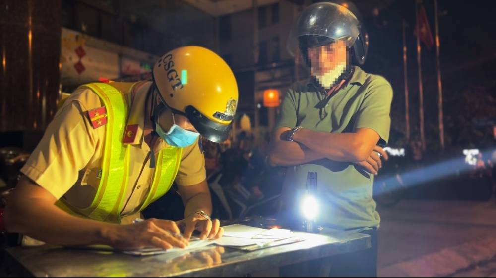 Biên bản vi phạm hành chính trong lĩnh vực giao thông đang được ký xác nhận