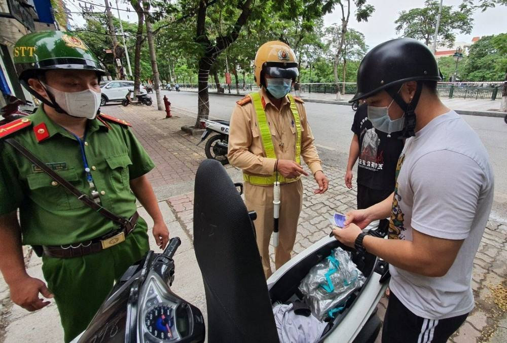 Cảnh sát giao thông đang làm việc với người điều khiển phương tiện vi phạm luật giao thông