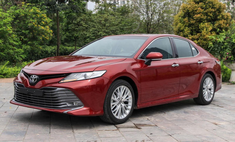 Chiếc Toyota Camry màu đỏ đậm đang di chuyển trên đường