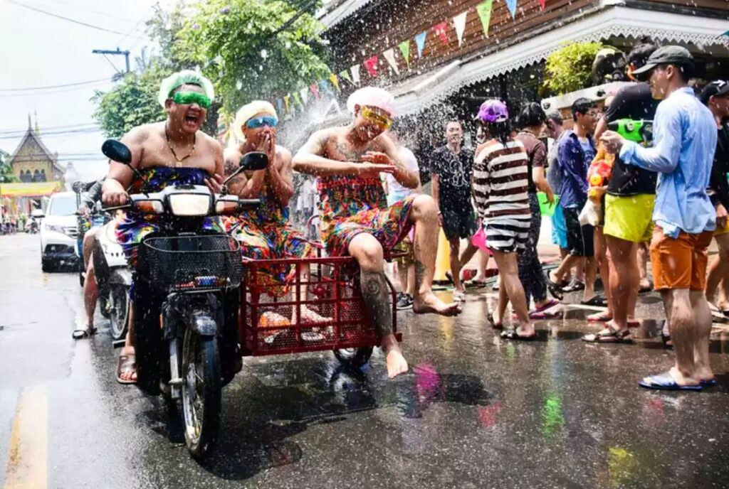 Du khách nước ngoài vui vẻ tham gia té nước cùng người dân địa phương trên một con phố ở Chiang Mai, trải nghiệm không khí quốc tế của Songkran.