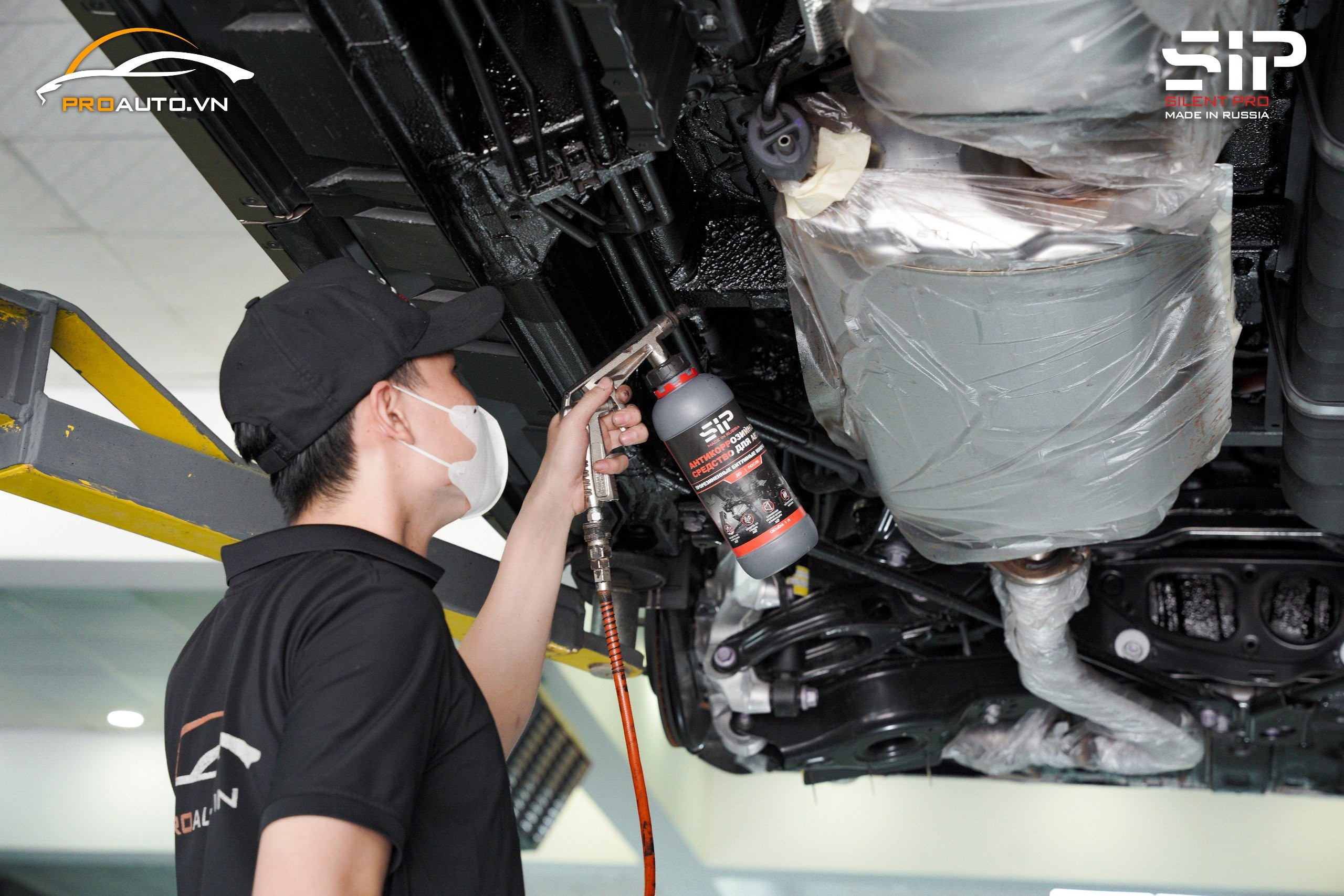 Hình ảnh kỹ thuật viên chuẩn bị gầm xe trước khi phun sơn phủ