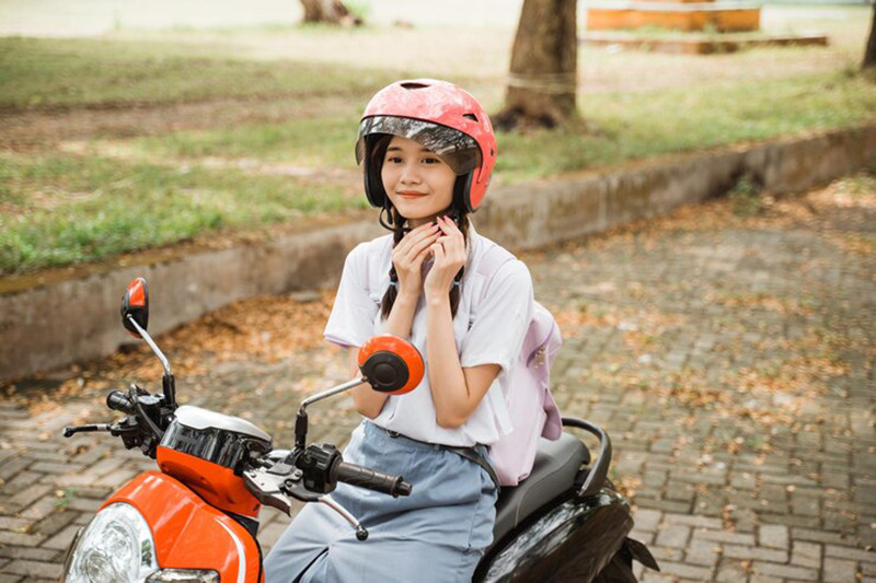 Người lái xe máy 50cc đang đi chậm rãi, tuân thủ đúng làn đường trên phố