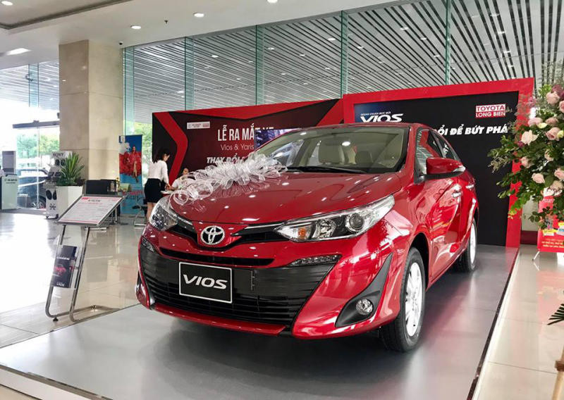 Xe Toyota Vios Limo màu trắng đang di chuyển trên đường